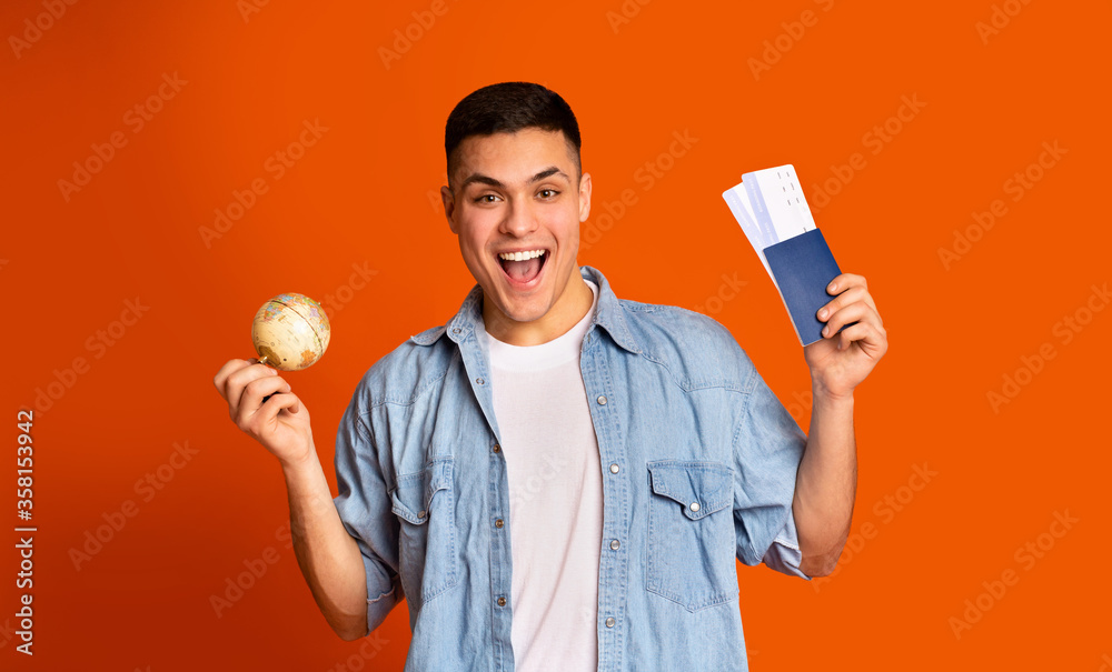 Delighted traveler with handy globe holding passport Delighted traveler with handy globe holding passport