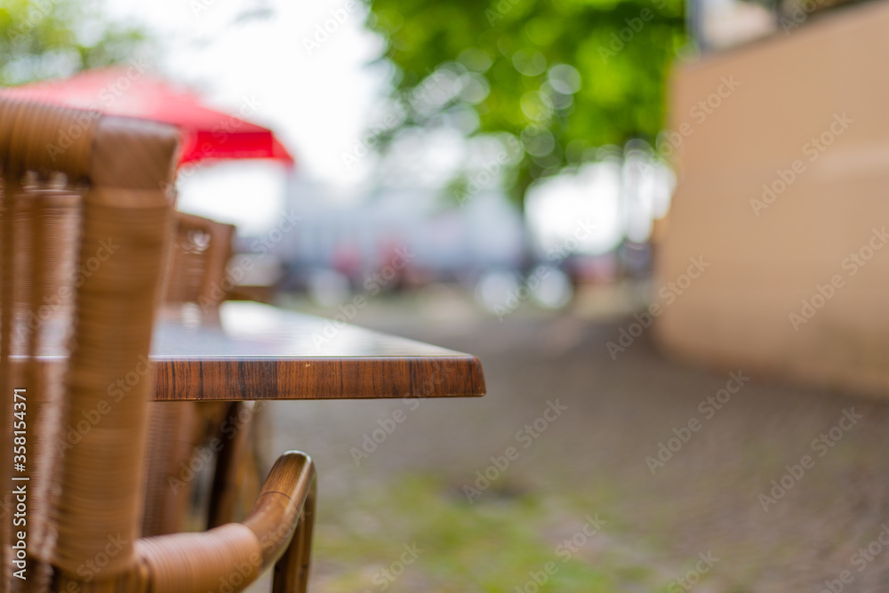 wooden chairs and tables in a  pedestrian area in front of a coffee