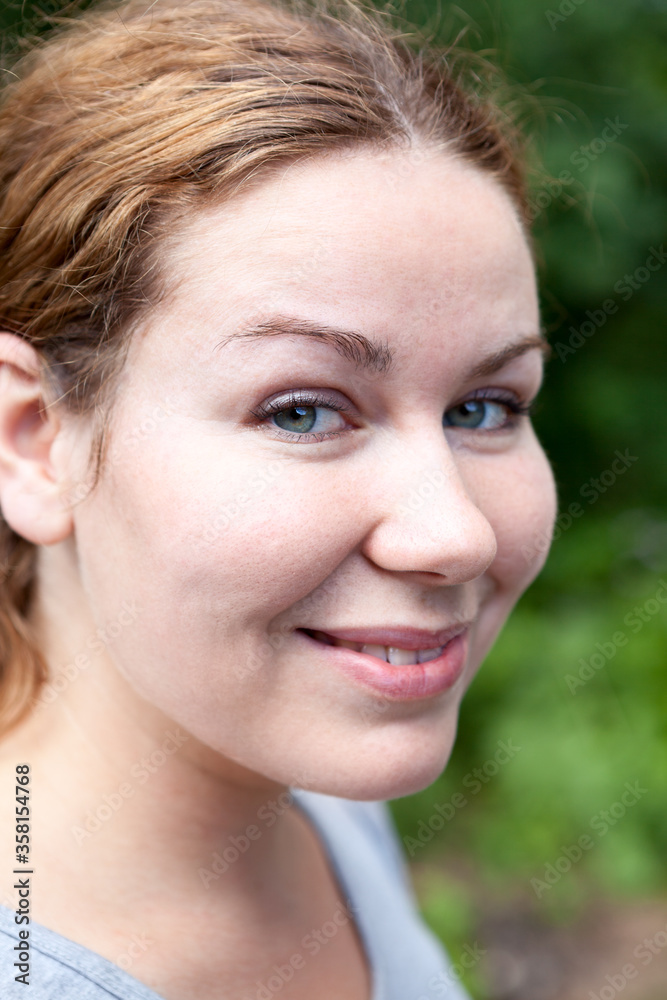 Facial portrait of smiling woman, looking at camera