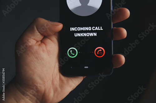 Unknown number calling in the middle of the night. Phone call from stranger. Person holding mobile and smartphone home
