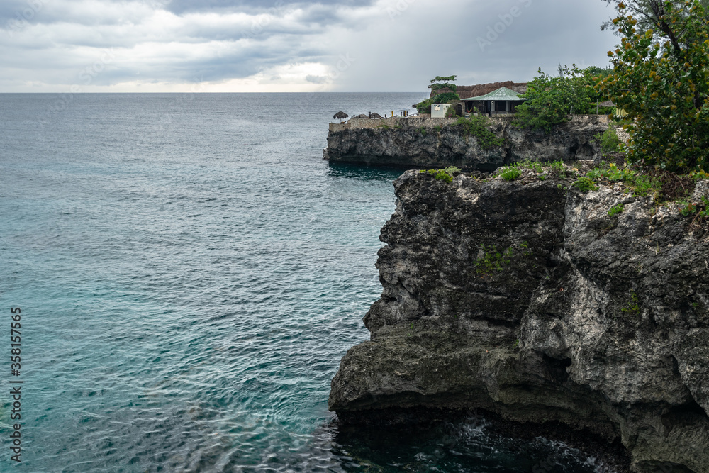 Scenic ocean view of coast cliffs and bays landscape on coastline in Negril, Jamaica. Seaside setting for tropical Caribbean island vacation. Cliff diving and snorkeling seascape location.