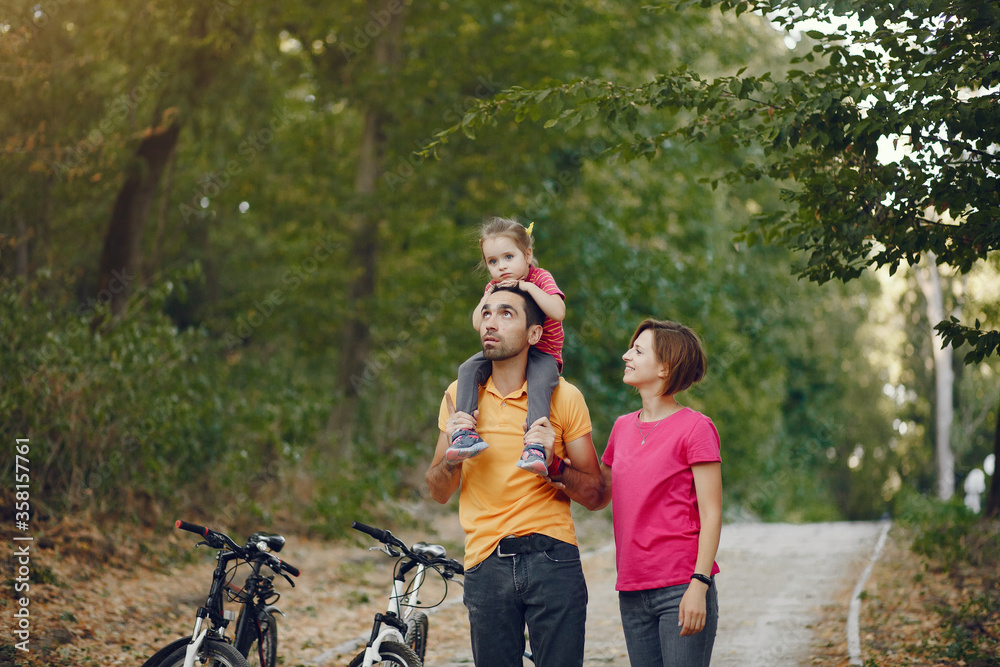 Family in a park. People with a bicycle. Parents with little daughter. Family in a park. People with a bicycle. Parents with little daughter.