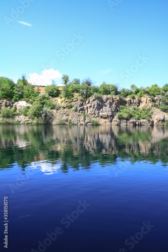 Beautiful river in the highlands in summer. Lake in an ecologically clean park reserve on a background of hills. A pretty landscape in the spring. Stock photo for design