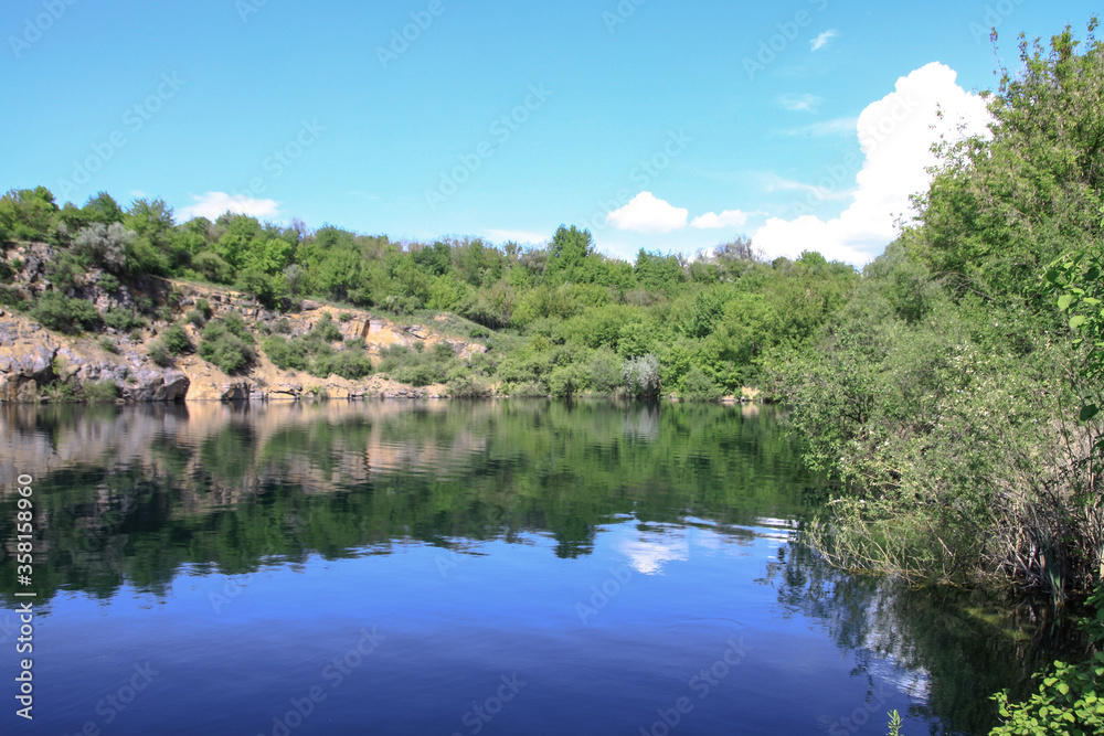 Beautiful river in the highlands in summer. Lake in an ecologically clean park reserve on a background of hills. A pretty landscape in the spring. Stock photo for design Beautiful river in the highlands in summer. Lake in an ecologically clean park reserve on a background of hills. A pretty landscape in the spring. Stock photo for design