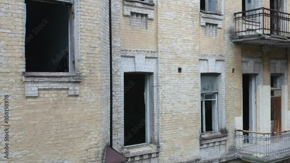 Broken windows of an abandoned ruined 19th century apartment building. Deserted old house. Aerial view Broken windows of an abandoned ruined 19th century apartment building. Deserted old house. Aerial view