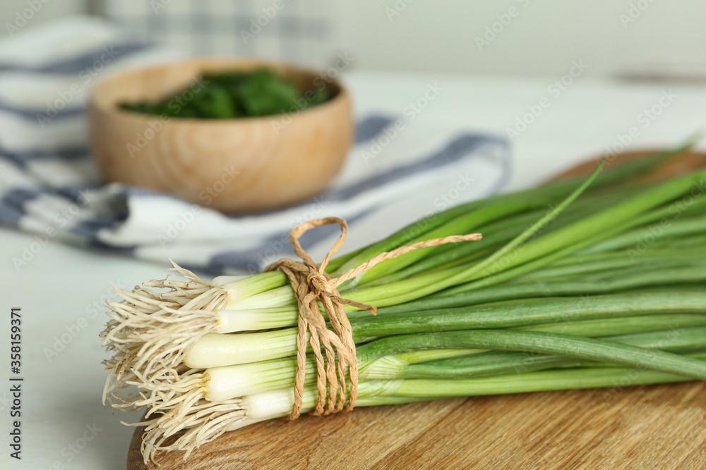 Fresh green spring onions on wooden board, closeup Fresh green spring onions on wooden board, closeup