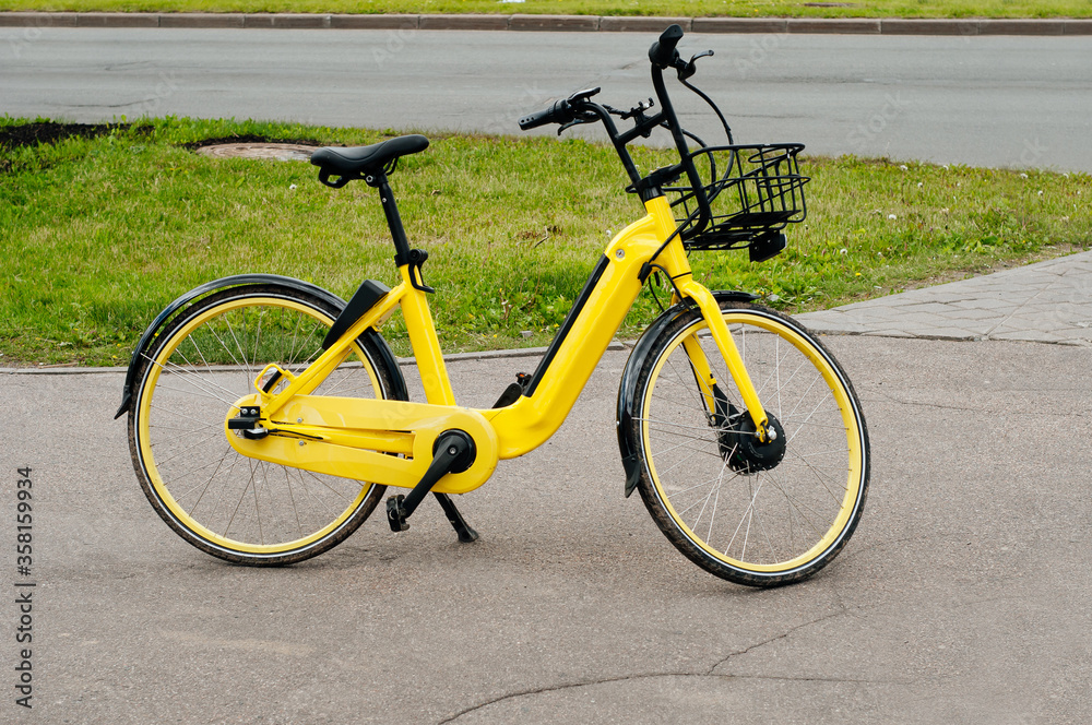 parked yellow rent-a-bike near sidewalk. ecological transport for recreation parked yellow rent-a-bike near sidewalk. ecological transport for recreation