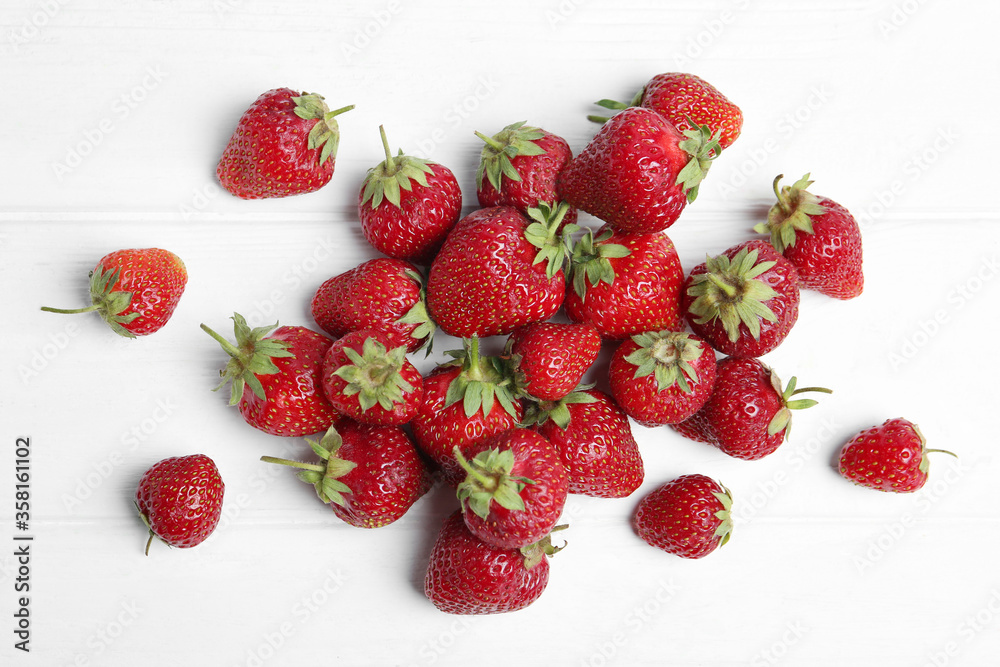 Delicious ripe strawberries on white wooden table, flat lay