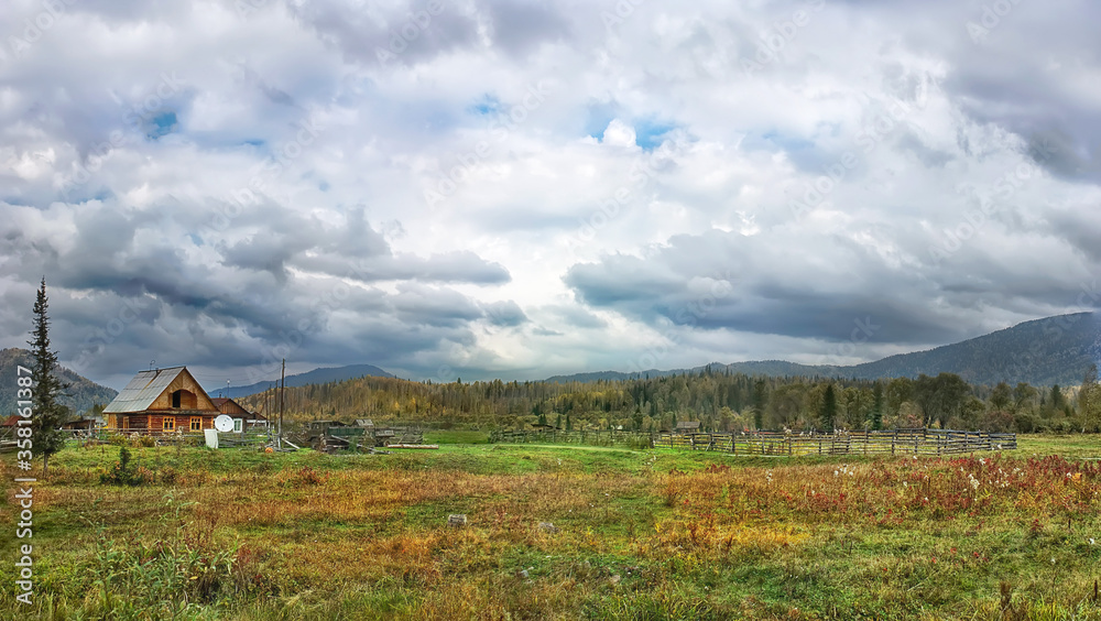 village house landscape in the mountains. Wildlife Taiga Forest. thunderstorm clouds in the sky, summer and autumn.