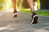 Unrecognizable black guy in sports shoes jogging at city park on sunny morning, closeup