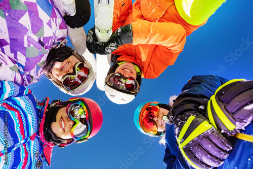 Happy girls look down with ski winter sport outfit masks and glasses standing together smiling