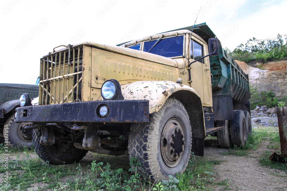 Old truck in very poor condition. A car stands in nature like abandoned metal rubbish. Stock photo background for design.