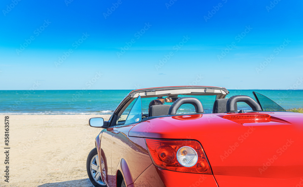 Red car on the beach. Vacation and freedom concept.