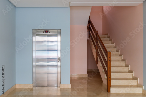 view of the elevator and stairwell in the entrance of a residential building
