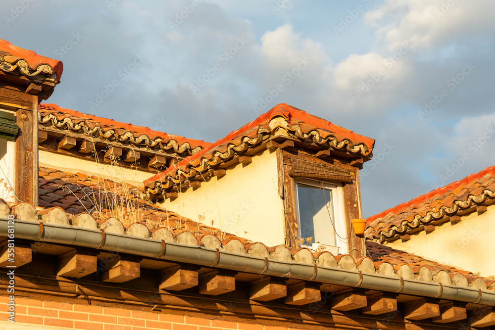Obraz premium View of rooftop and sky with clouds at sunset. Roof tiles
