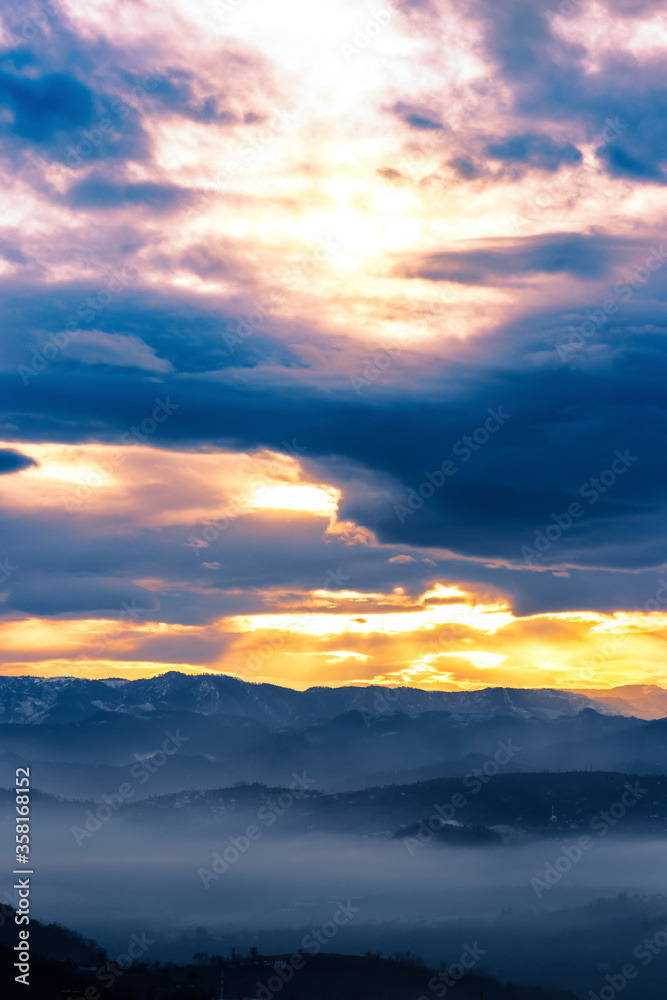 Foggy landscape with light leaking cloudy sky