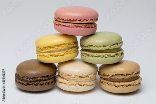 A stack of pastel-coloured macarons indoors against a soft neutral background.