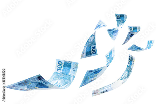 banknotes of one hundred reais from brazil falling on isolated white background. Concept of falling money, devaluation of the real or financial crisis. photo