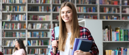 Young pretty student with books and backpack in library, space for text. Banner design