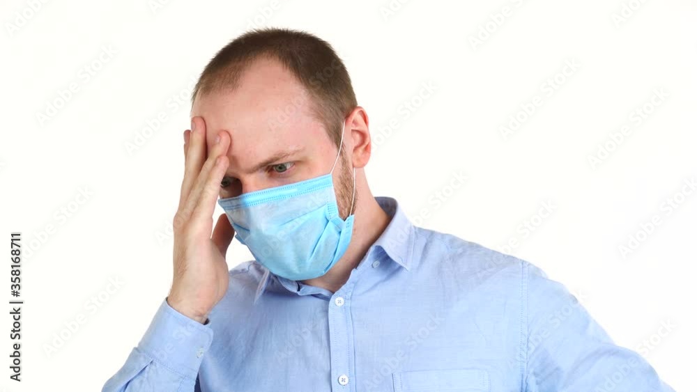 Handsome european man in protective mask having a headache, first symptoms of fever. Handsome european man in protective mask having a headache, first symptoms of fever.