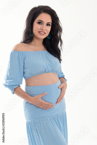 Happy smiling pregnant woman touching her belly isolated on white background. Pregnancy concept studio portrait Mother expecting baby. Baby tea.