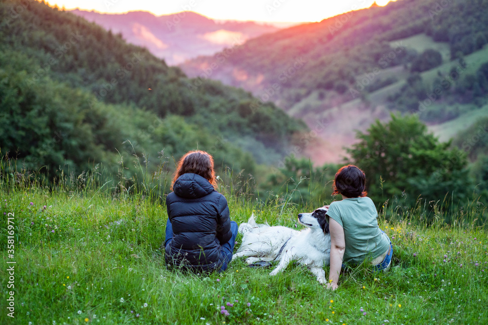woman and dog in amazing summer landscape at sunset