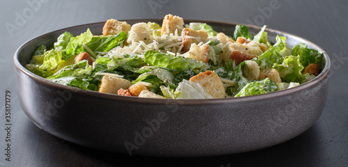 fresh caesar salad with croutons and parmasan cheese in bowl