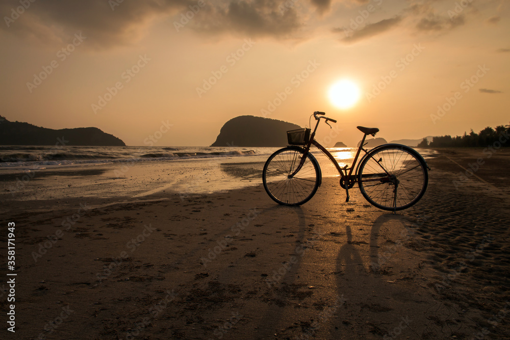 Fototapeta premium silhouette of bicycle at beach, bicycles on beach sunset or sunrise