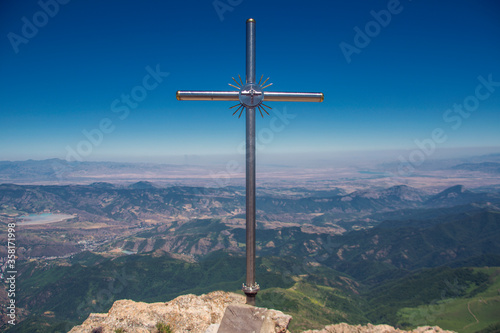 Metal christian cross on top of a high mountain