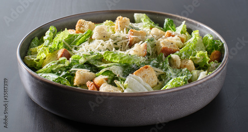 fresh caesar salad with croutons and parmasan cheese in bowl