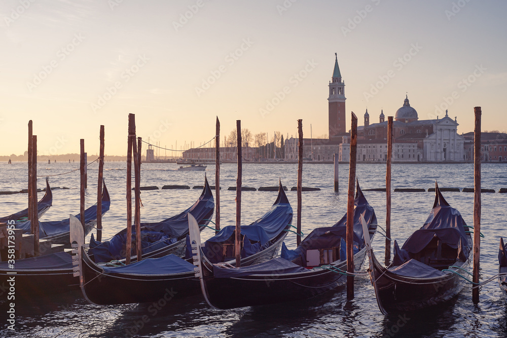 Venetian gondolas in the morning near Saint Mark's square with San Giorgio Maggiore church at background in Venice, Italy