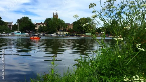 4k, A small inflatable boat pass by on river Thames at Hampton Court summer holyday