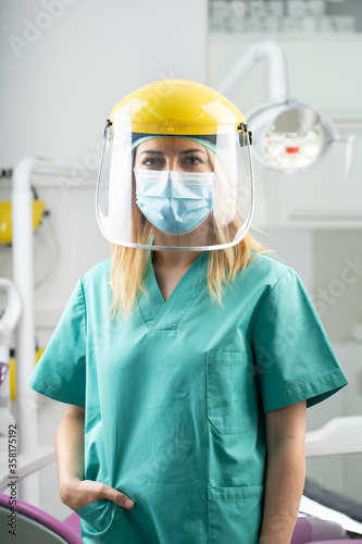 Mujer dentista con mascarilla y equipo de protección individual, EPI, garantizando la máxima seguridad para los pacientes en contra del coronavirus COVID-19