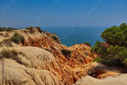 Sandstone Cliffs near Marinha Beach in Algarve Coast with Green Tree. South of Portugal and its Beauty. © nicolecedik