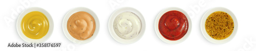 Collection of various sauces in white ceramic bowl top view. Mustard, burger sauce, tartar, ketchup isolated on white background.      photo