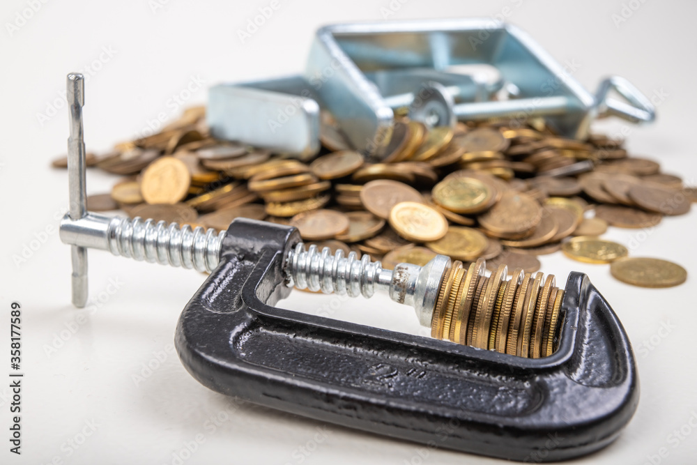 Coins squeezed in a carpenter's clamp. The image of the European currency in crisis. Coins squeezed in a carpenter's clamp. The image of the European currency in crisis.