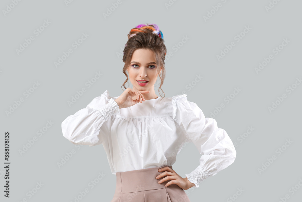 Beautiful young woman with unusual hair on grey background Beautiful young woman with unusual hair on grey background