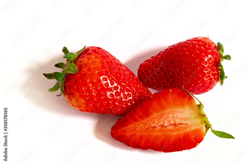 Two and a half red strawberries fruits, closeup photo isolated on white background