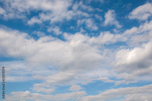 White clouds on a blue sky. Beautiful natural background. © Tetiana