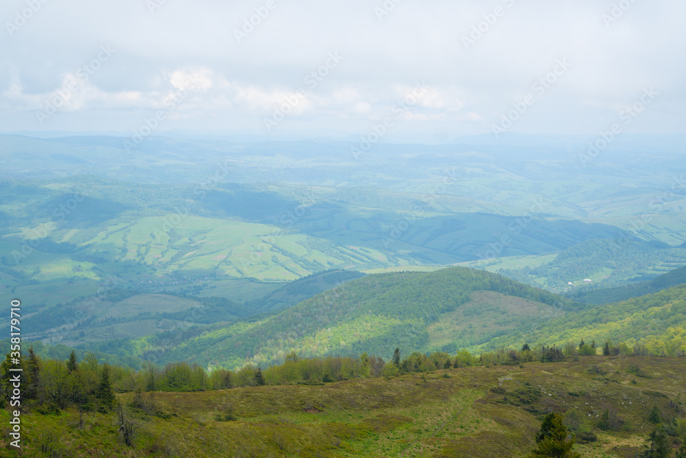 scenic view from the mountain on the forest and the village below. summer Carpathians in Ukraine. boundless space