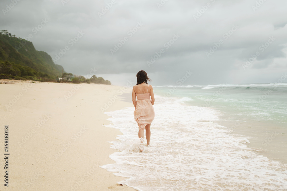 Beautiful woman on the beach of Bali on a background of mountains and the ocean Beautiful woman on the beach of Bali on a background of mountains and the ocean