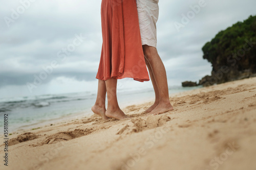 Legs of a young beautiful couple on a sandy beach of Indonesia © kavastudio
