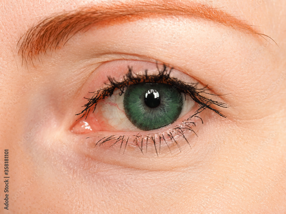 Female left blue eye tinted in green colour with special contact lens Female left blue eye tinted in green colour with special contact lens