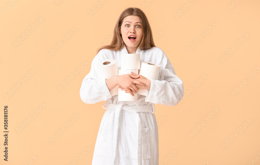 Surprised young woman with many rolls of toilet paper on color background Surprised young woman with many rolls of toilet paper on color background