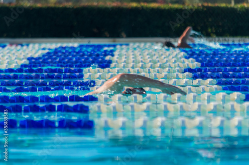 A swimmer's arm surfaces from the water in swim lanes photo