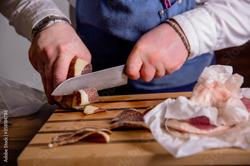 Chef cuts pieces of horse meat on a cutting board with a knife. Master class in the kitchen. The process of cooking. Step by step. Tutorial. Close-up
