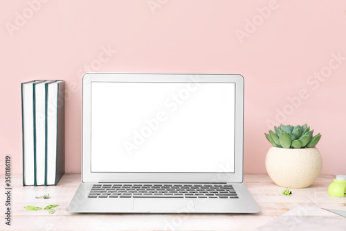 Modern laptop on table in room