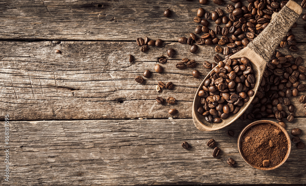 Coffee beans in wooden spoon on wood background. Coffee beans in wooden spoon on wood background.