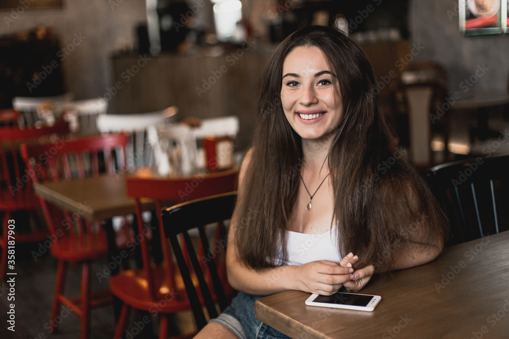 Beautiful woman posing for the camera sitting in a cafe. Beautiful woman posing for the camera sitting in a cafe.