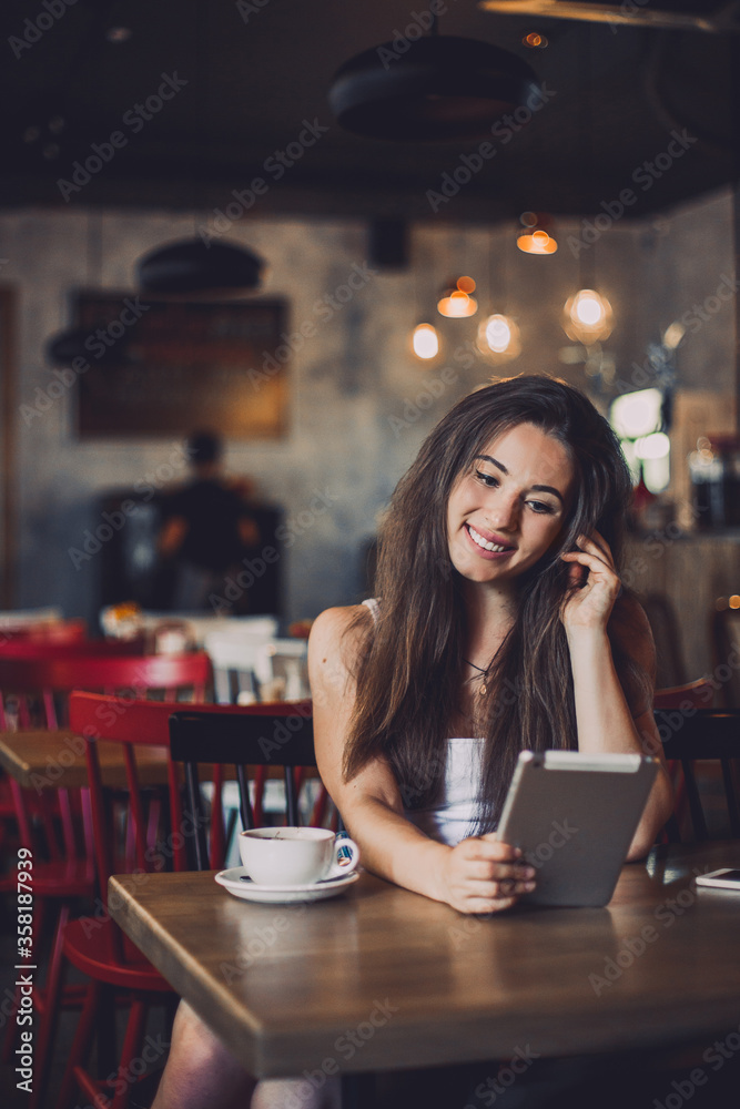 Business woman using tablet and drinking coffee in a cafe.